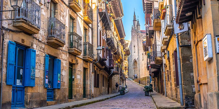 A view of the old quarter of Hondarribia shows traditional stone buildings with colourful wooden doors. 